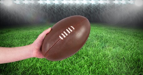 Composition of male rugby player holding ball at stadium