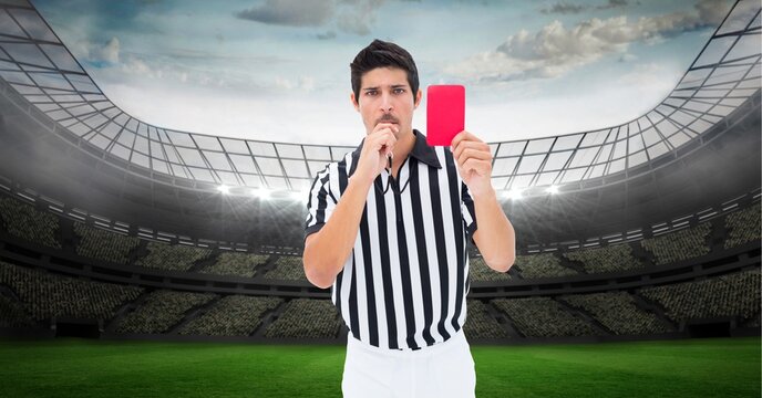 Composition of male referee holding red card at football stadium