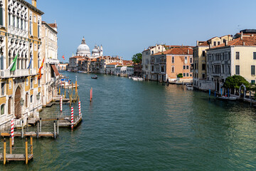Fototapeta na wymiar View of the Grand Canal with close up of Santa Maria della Salute, famous Roman Catholic cathedral, seen from Ponte Dell'Accademia