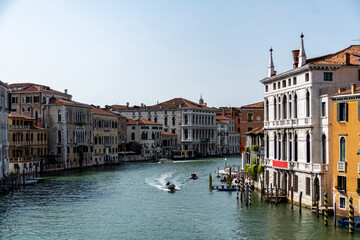 Fototapeta na wymiar The quiet Grand Canal with a single boat sailing seen from the Ponte dell Accademia bridge on a sunny day in summer