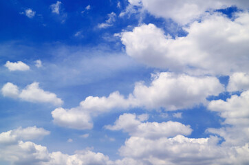 Naklejka na ściany i meble Fluffy white cumulus clouds floating on the blue sky