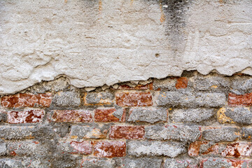 Plastered bricks with pieces of stucco. red, textured wall with a damaged surface. Old, abstract background.