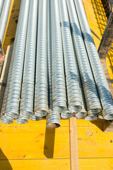 a bundle of corrugated metal pipes at a construction site