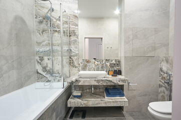 modern minimalist stone bathroom with shower and washing machine