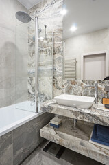 modern minimalist stone bathroom with shower and washing machine