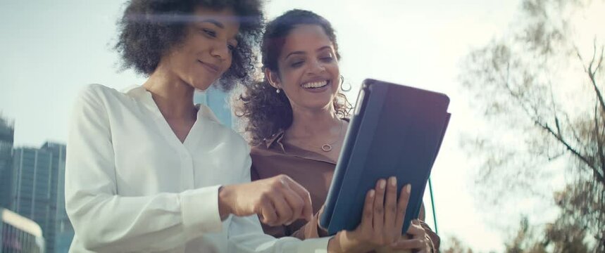 Video of two businesswomen with digital tablet in the city. Shot with RED helium camera in 8K.