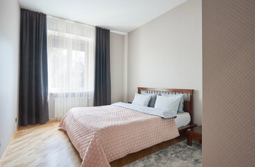 double king - size wooden bed made of oak in a bright bedroom or hotel room