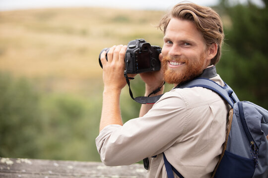 happy man taking photos in nature