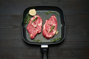 Fresh raw beef or pork steaks on frying pan