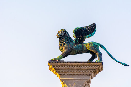 Winged Lion statue at Piazza San Marco (St Mark`s Square) on blue sky background, Venice, Italy.