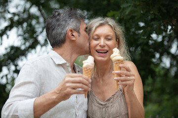 senior couple hugging and laughing together eating ice cream