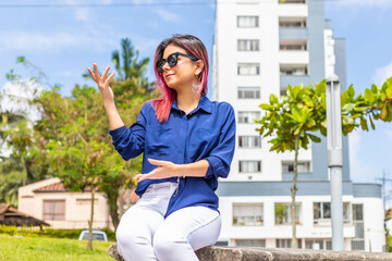Businesswoman sitting in outdoors gesturing with her hands and communicating