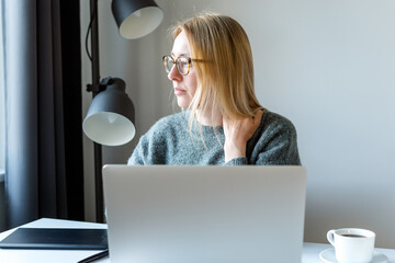 Fototapeta premium Woman at the work desk in front of a laptop.