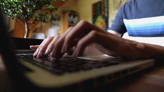 Vue rapproch&eacute;e d&rsquo;un &eacute;tudiant &eacute;crivant rapidement sur un clavier d'ordinateur portable. Male student hands typing fast on laptop, close up view.