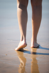 Pies de mujer andando descalza por la playa