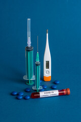 Medicine tablet, Thermometer and syringe or injection with a Test tube containing a blood sample for testing to the presence of coronavirus / COVID-19