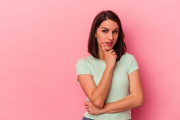 Obraz premium Young caucasian woman isolated on pink background looking sideways with doubtful and skeptical expression.