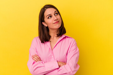 Young caucasian woman isolated on yellow background dreaming of achieving goals and purposes