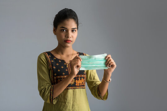 Portrait of young woman showing opened medical mask. quarantine measures and life saving concept