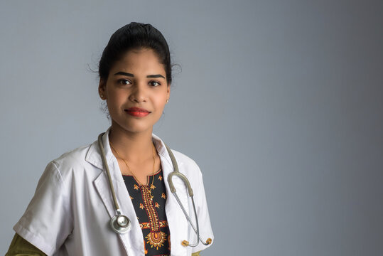 Woman doctor with a stethoscope on grey background