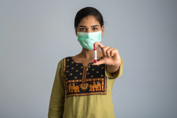 Woman holding a test tube with blood sample for coronavirus or 2019-nCoV analyzing.