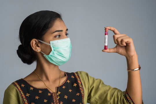 Woman holding a test tube with blood sample for coronavirus or 2019-nCoV analyzing.