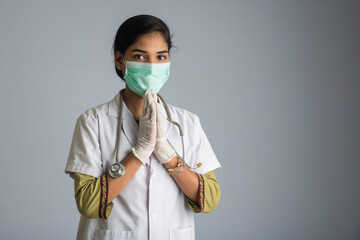 Young woman Doctor doing Namaste because of outbreak of COVID-19. New greeting to avoid the spread of coronavirus instead of greeting with a hug or handshake.