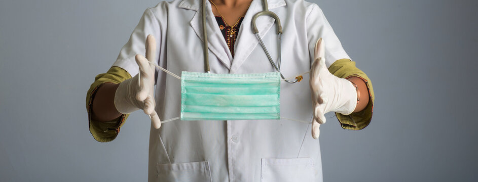 Portrait of young woman doctor showing opened medical mask. quarantine measures and life saving concept