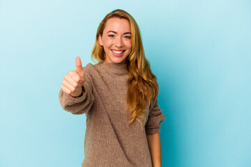 Caucasian woman isolated on blue background smiling and raising thumb up