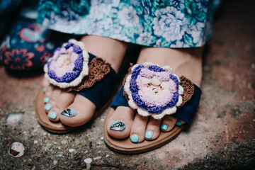 Female feet. Nails with blue pedicure in beautiful homemade summer shoes
