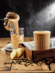 The traditional Indian drink masala chai is poured into a faceted glass glass. Copy space.