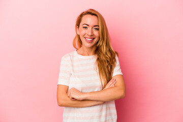 Fototapeta premium Caucasian blonde woman isolated on pink background who feels confident, crossing arms with determination.
