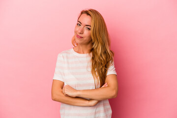 Fototapeta premium Caucasian blonde woman isolated on pink background suspicious, uncertain, examining you.