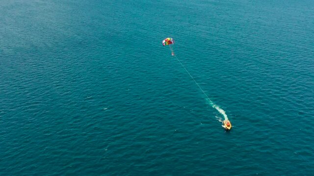 Tourists on a parachute over the sea, aerial view. Tourists parasailing on the Boracay, Philippines.