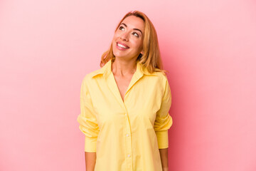 Fototapeta premium Caucasian blonde woman isolated on pink background relaxed and happy laughing, neck stretched showing teeth.
