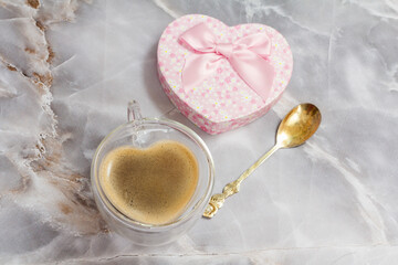 Cup of coffee and gift box on kitchen desk.