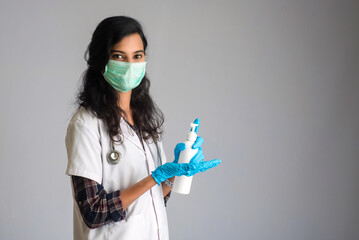 Portrait of woman doctor showing a bottle of sanitizing gel for hands cleaning.