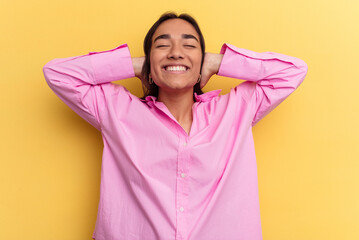 Young mixed race woman isolated on yellow background feeling confident, with hands behind the head.