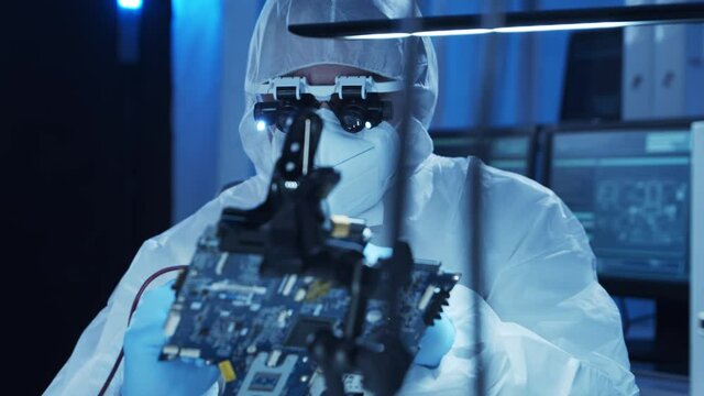 Professional engineer is developing a modern microprocessor in a futuristic laboratory using technology and computer software. Inventions and science concept.