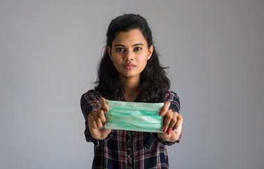 Portrait of young woman showing opened medical mask. quarantine measures and life saving concept