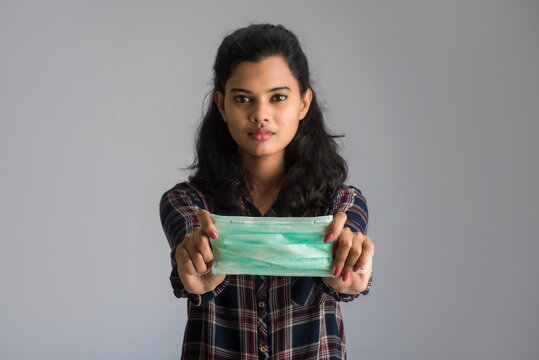 Portrait of young woman showing opened medical mask. quarantine measures and life saving concept