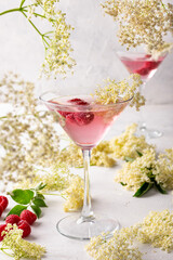 Gin and tonic with elderflower refreshing summer pink cocktail garnished with raspberries
