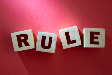 Obraz premium Wooden cube block with RULE business word on table background. Mission, Vision and core values concept