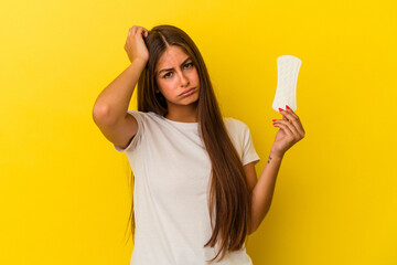 Young caucasian woman holding a compress isolated on yellow background being shocked, she has remembered important meeting.