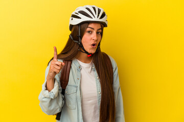 Young student caucasian woman wearing a bike helmet isolated on yellow background having an idea, inspiration concept.