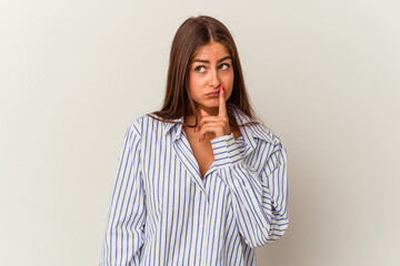 Obraz premium Young caucasian woman isolated on white background looking sideways with doubtful and skeptical expression.