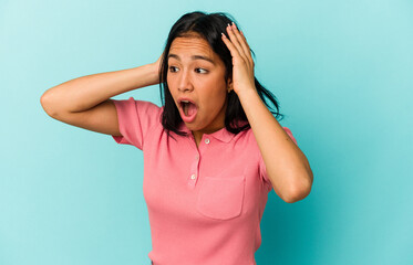 Young Venezuelan woman isolated on blue background screaming, very excited, passionate, satisfied with something.