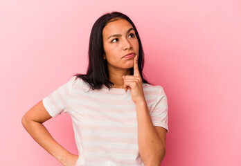 Young Venezuelan woman isolated on pink background keeping a secret or asking for silence.
