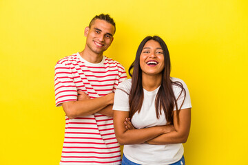 Obraz premium Young latin couple isolated on yellow background laughing and having fun.