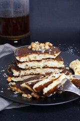A stack of cut pancakes with a banana.